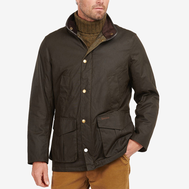 Barbour Hereford Wax Jacket i Olive med vaxad bomull, läderdetaljer, handvärmarfickor och klassisk countrydesign.